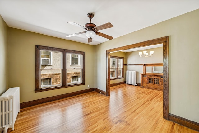 3441 Portland Ave Unit 1, Minneapolis, MN 55407 - unfurnished living room featuring radiator, baseboards, and a chandelier