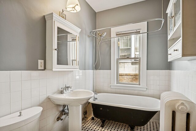3441 Portland Ave Unit 1, Minneapolis, MN 55407 - bathroom featuring tile walls, a freestanding tub, toilet, radiator heating unit, and a shower