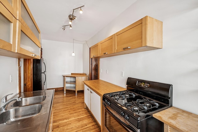 3441 Portland Ave Unit 1, Minneapolis, MN 55407 - kitchen featuring black gas stove, a sink, freestanding refrigerator, light wood-type flooring, and butcher block counters