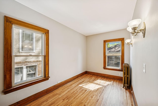 3441 Portland Ave Unit 1, Minneapolis, MN 55407 - unfurnished room featuring baseboards, radiator heating unit, and hardwood / wood-style flooring