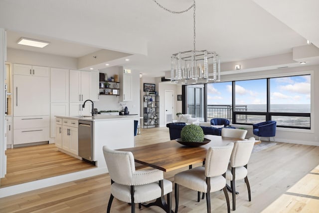 dining room featuring a chandelier, light wood finished floors, recessed lighting, and baseboards