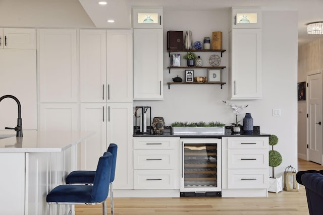 indoor dry bar with beverage cooler, recessed lighting, and light wood-style flooring