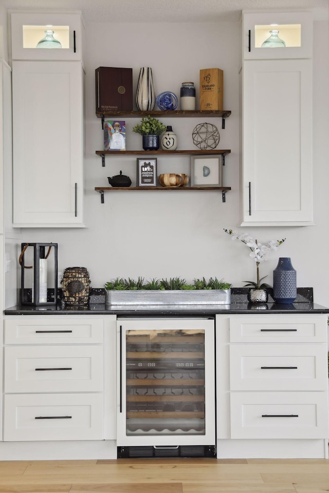 indoor dry bar with wine cooler and light wood-style floors