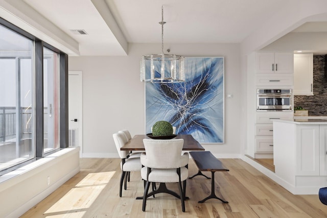 dining space featuring light wood finished floors and baseboards