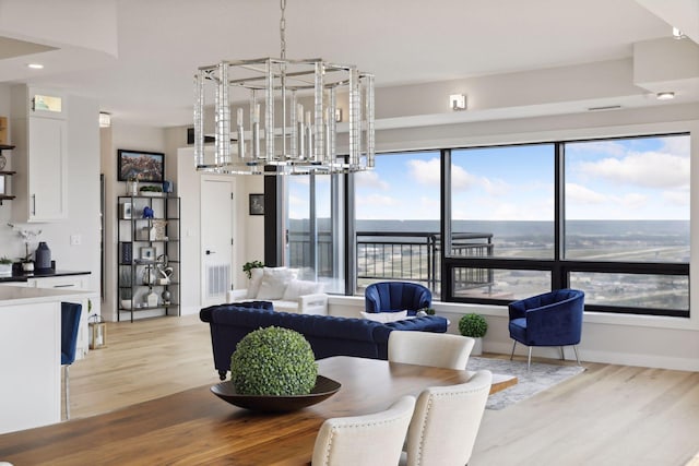 dining space featuring a chandelier, light wood finished floors, and plenty of natural light