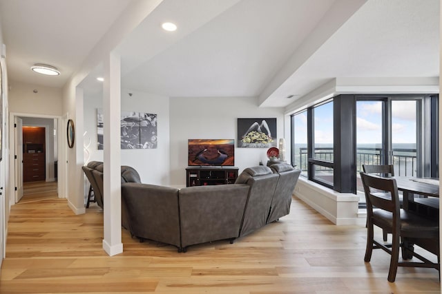 living area with baseboards, light wood-style flooring, and recessed lighting