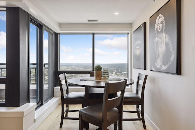 dining area with light wood-style flooring, plenty of natural light, baseboards, and recessed lighting