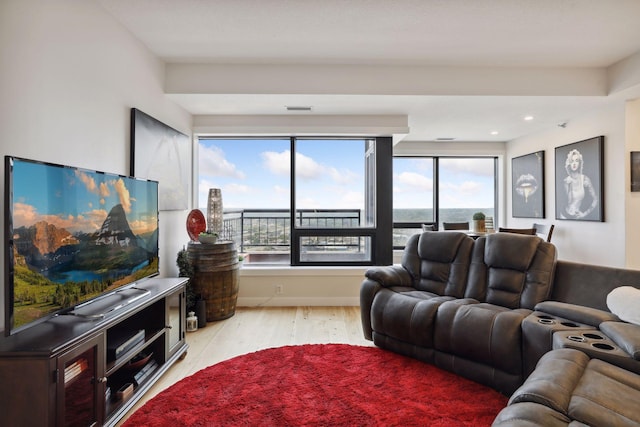 living room with light wood-style floors, healthy amount of natural light, and recessed lighting