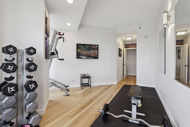 exercise room featuring wood finished floors, recessed lighting, and baseboards