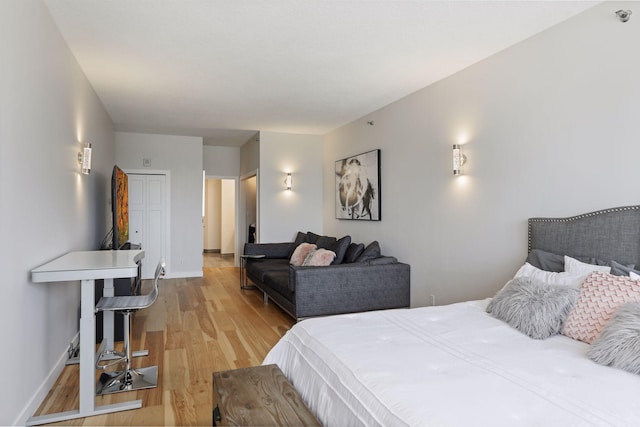 bedroom with light wood finished floors and baseboards