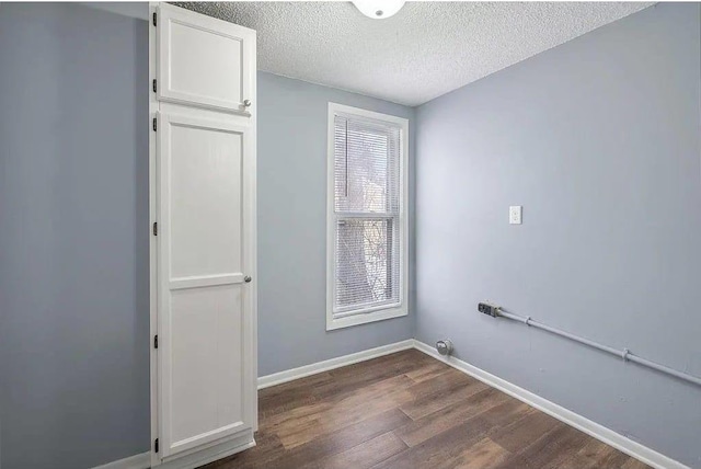 2723 Dupont Ave N, Minneapolis, MN 55411 - washroom with dark wood-style flooring, a textured ceiling, and baseboards