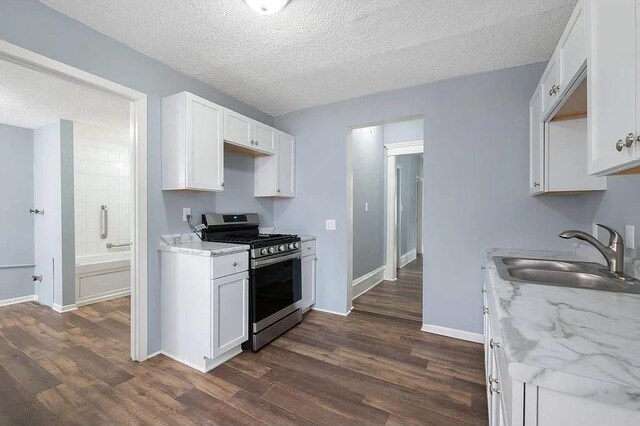 2723 Dupont Ave N, Minneapolis, MN 55411 - kitchen featuring gas range, a sink, dark wood-type flooring, white cabinetry, and a textured ceiling
