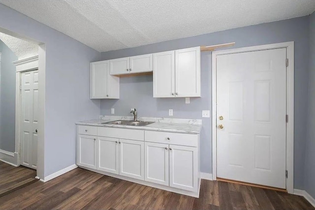 2723 Dupont Ave N, Minneapolis, MN 55411 - kitchen featuring a sink, dark wood-type flooring, white cabinetry, baseboards, and a textured ceiling