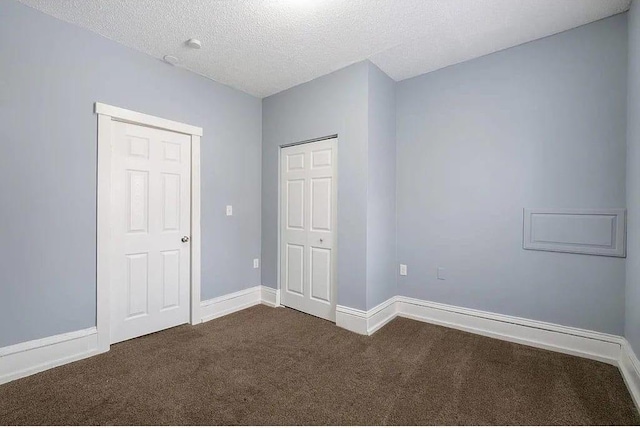 2723 Dupont Ave N, Minneapolis, MN 55411 - unfurnished bedroom featuring dark colored carpet, baseboards, and a textured ceiling
