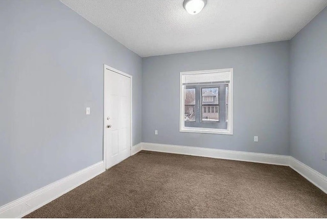 2723 Dupont Ave N, Minneapolis, MN 55411 - spare room with dark carpet, baseboards, and a textured ceiling