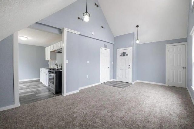 2723 Dupont Ave N, Minneapolis, MN 55411 - unfurnished living room featuring dark carpet, high vaulted ceiling, and baseboards