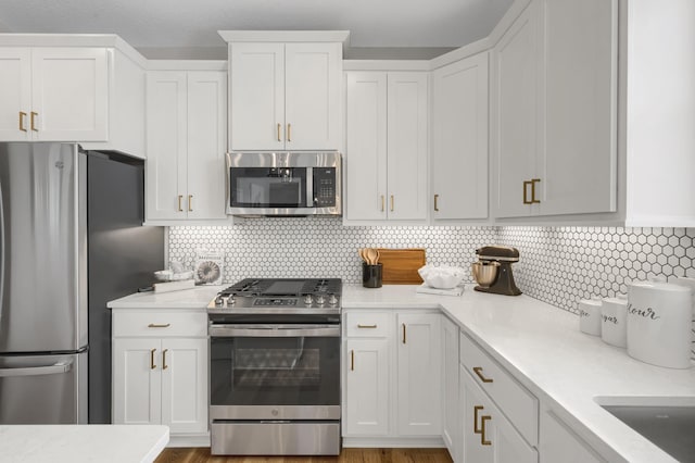 19307 Colonial Trl, Farmington, MN 55024 - kitchen featuring appliances with stainless steel finishes, light countertops, white cabinets, and backsplash