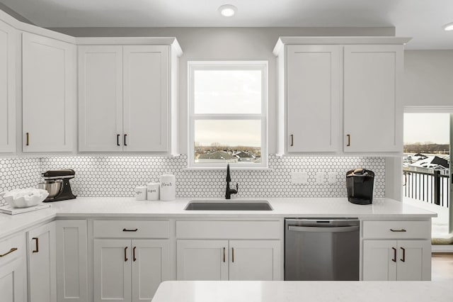 19307 Colonial Trl, Farmington, MN 55024 - kitchen with stainless steel dishwasher, a sink, white cabinets, and decorative backsplash