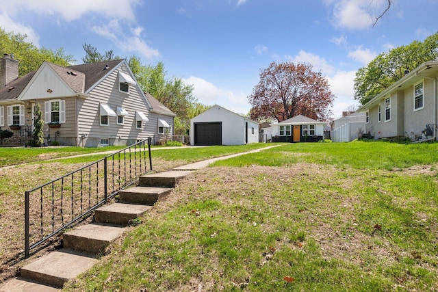 view of grassy yard with a garage and an outdoor structure