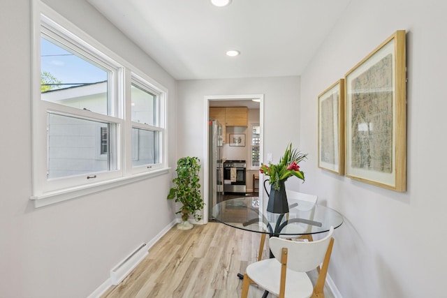 hallway featuring healthy amount of natural light, wood finished floors, baseboards, and recessed lighting