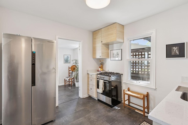 kitchen featuring stainless steel appliances, light brown cabinets, baseboards, and light stone countertops