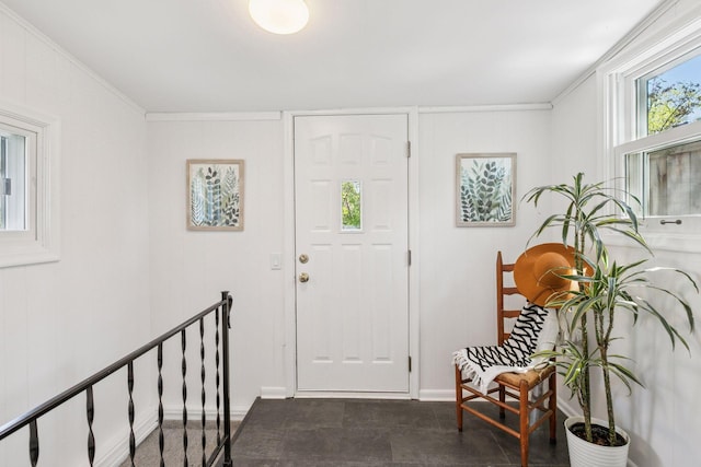 entrance foyer featuring crown molding and baseboards