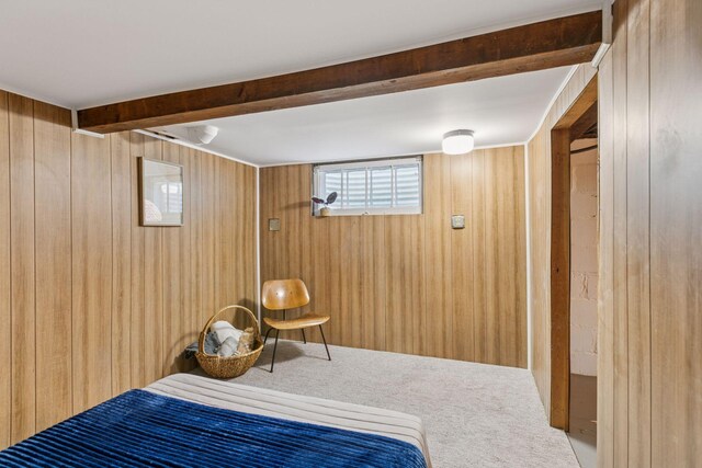 bedroom featuring carpet floors, wood walls, and beam ceiling