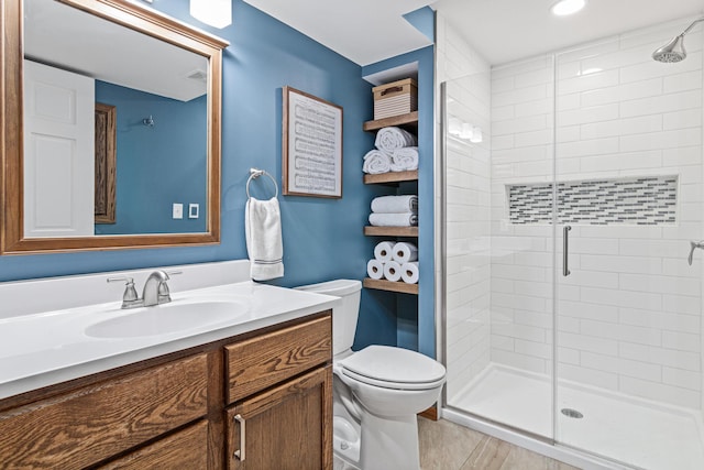 full bathroom with a shower stall, toilet, and vanity