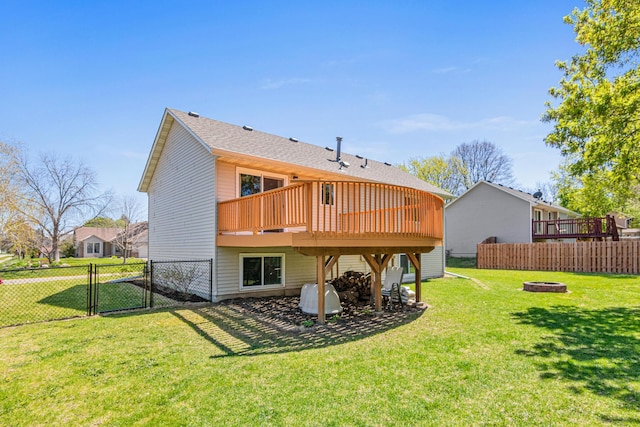 back of house featuring a gate, a deck, and a fire pit