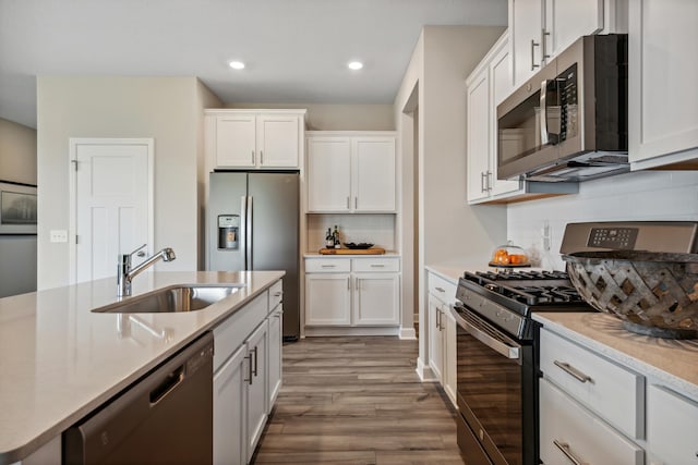 22654 Isla Way, Rogers, MN 55374 - kitchen with appliances with stainless steel finishes, a sink, white cabinetry, recessed lighting, and wood finished floors