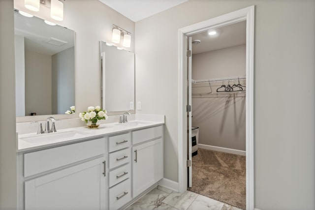 22654 Isla Way, Rogers, MN 55374 - bathroom featuring double vanity, a spacious closet, marble finish floors, and baseboards