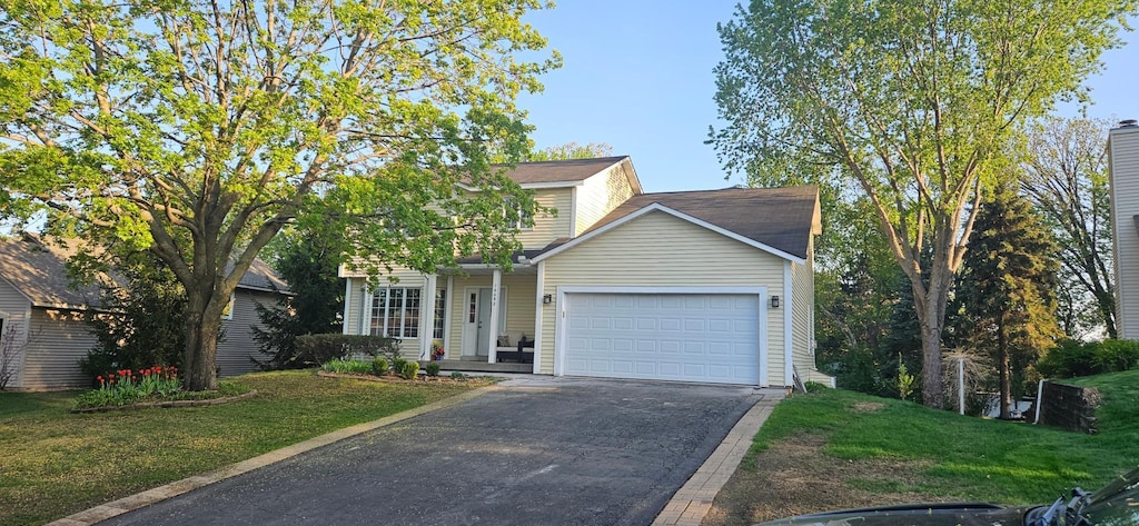 traditional-style home featuring driveway, a garage, and a front yard