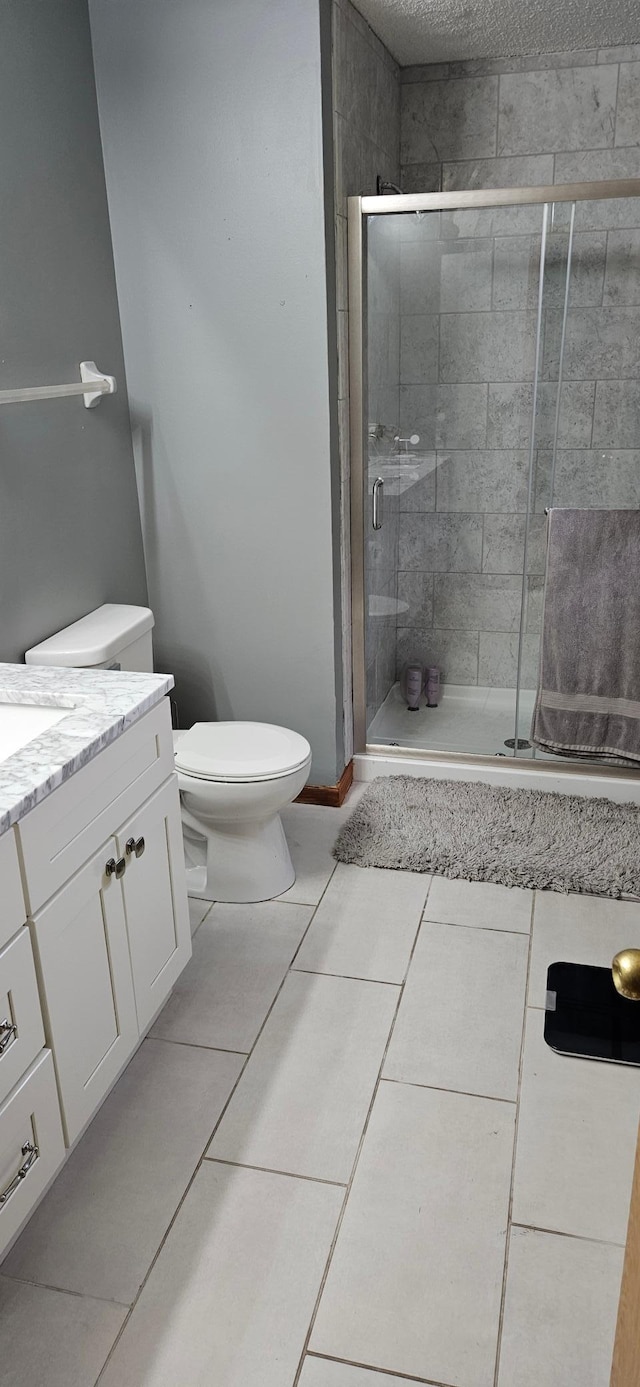 14092 Dearborn Path, Rosemount, MN 55068 - full bathroom featuring vanity, toilet, a stall shower, tile patterned floors, and a textured ceiling