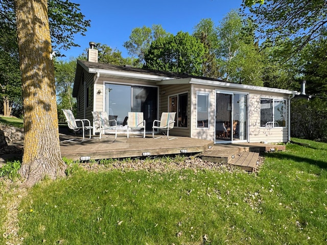 43084 335th Ave, Dora Twp, MN 56528 - back of property with a chimney, a deck, and a lawn