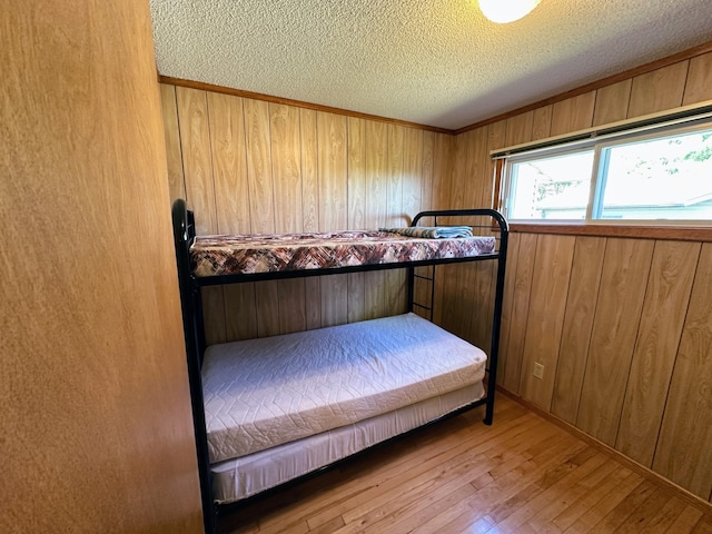 43084 335th Ave, Dora Twp, MN 56528 - bedroom featuring a textured ceiling, hardwood / wood-style floors, and wood walls