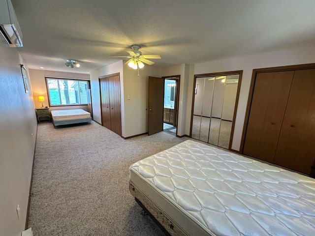 43084 335th Ave, Dora Twp, MN 56528 - bedroom featuring two closets, light colored carpet, a wall mounted AC, ceiling fan, and baseboards