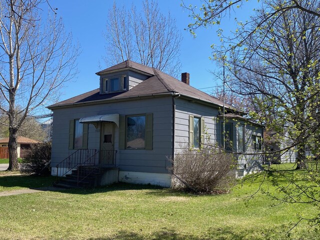 402 Main St, Mahnomen, MN 56557 - bungalow featuring a front lawn, a chimney, and roof with shingles