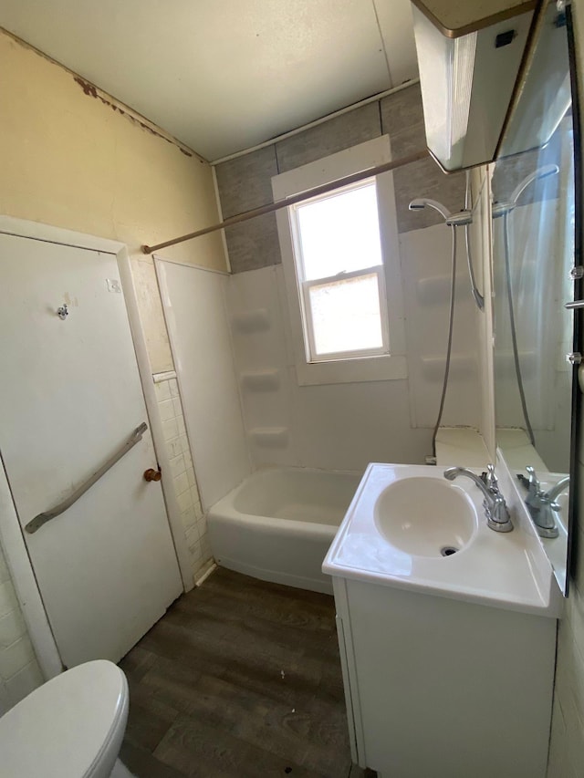bathroom with wood finished floors, vanity, toilet, and shower / bathtub combination