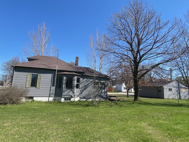 back of property with a yard and a chimney