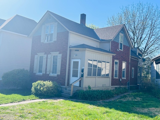 852 4th St E, Saint Paul, MN 55106 - view of front of house featuring entry steps, a chimney, a front lawn, and brick siding