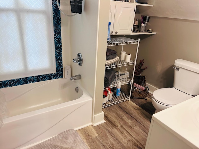 852 4th St E, Saint Paul, MN 55106 - bathroom featuring wood finished floors, toilet, baseboards, and bathtub / shower combination