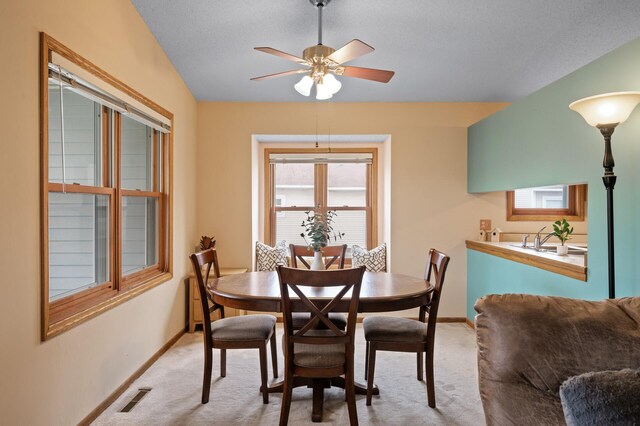dining room with carpet floors, a ceiling fan, baseboards, and healthy amount of natural light