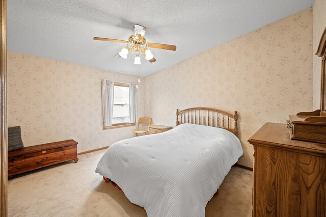 carpeted bedroom featuring wallpapered walls, baseboards, and a ceiling fan