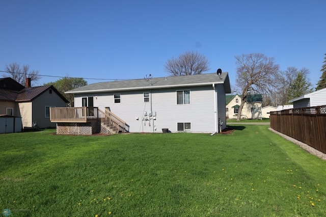 back of house with a deck, a lawn, a storage shed, and an outdoor structure