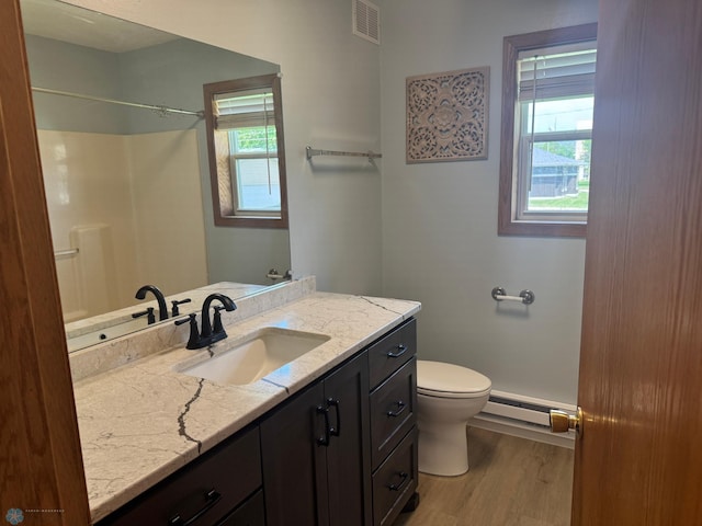 316 4th S, Breckenridge, MN 56520 - bathroom featuring a baseboard radiator, toilet, wood finished floors, and healthy amount of natural light