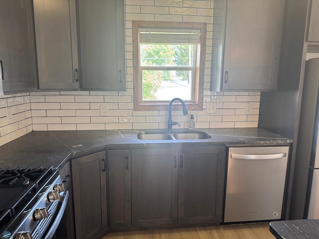 316 4th S, Breckenridge, MN 56520 - kitchen with stainless steel appliances, a sink, decorative backsplash, and dark stone counters