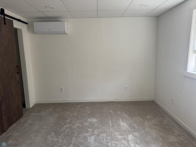 316 4th S, Breckenridge, MN 56520 - basement with a wall unit AC, a barn door, carpet, a paneled ceiling, and baseboards