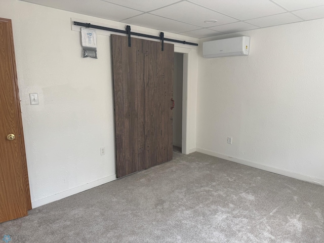 316 4th S, Breckenridge, MN 56520 - unfurnished bedroom featuring an AC wall unit, carpet flooring, a barn door, baseboards, and a drop ceiling