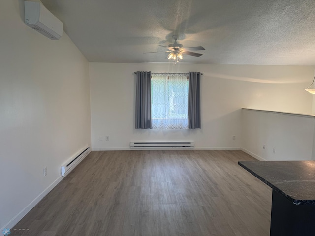 316 4th S, Breckenridge, MN 56520 - empty room with a baseboard radiator, an AC wall unit, a ceiling fan, wood finished floors, and a textured ceiling