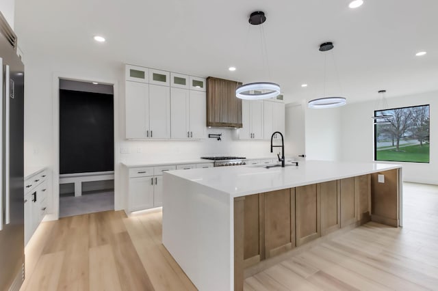 1796 Cobblestone Ct, Hastings, MN 55033 - kitchen featuring a sink, light wood-style flooring, a large island, light countertops, and recessed lighting